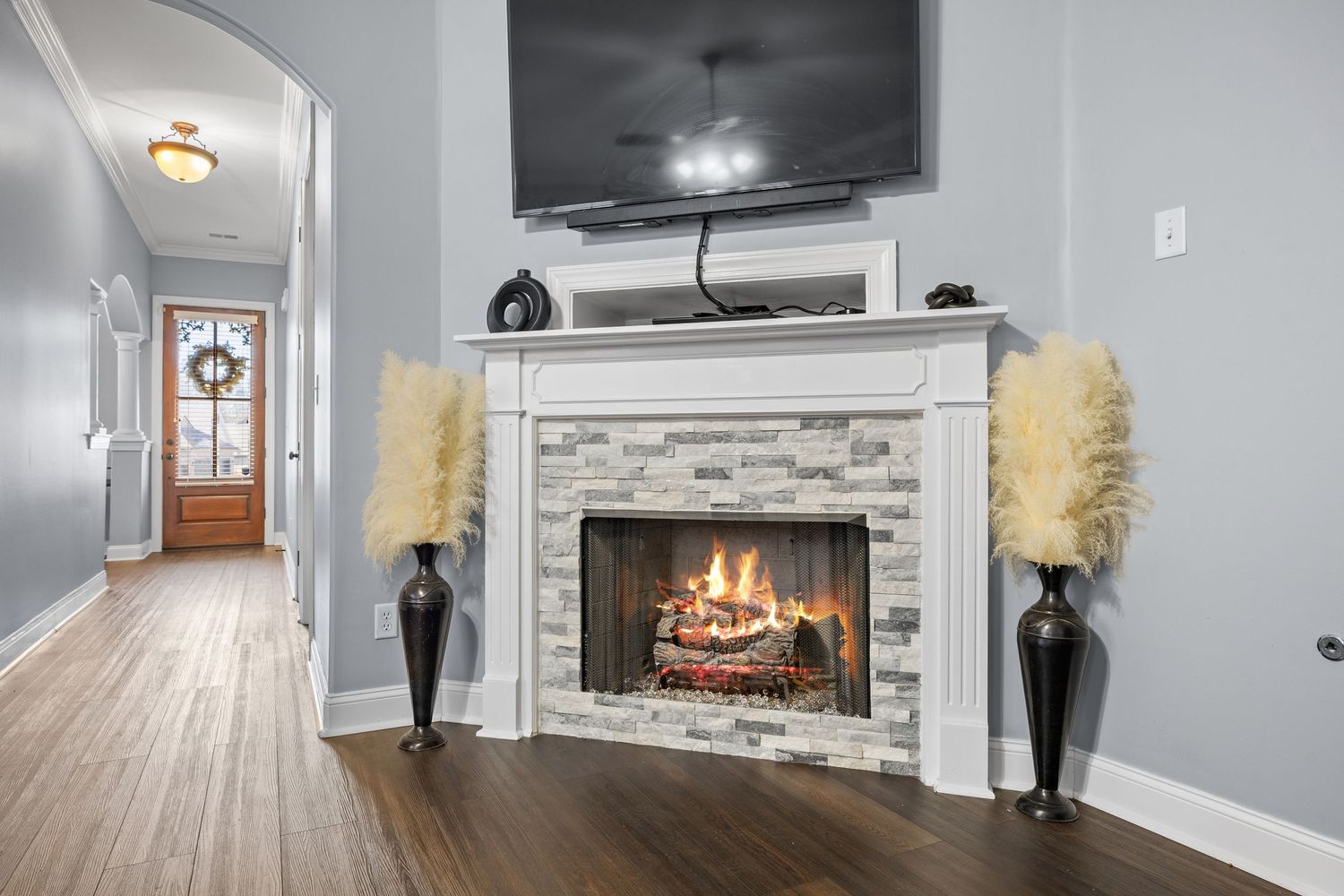 Living room with mounted TV, fireplace, and gray walls in contemporary style.