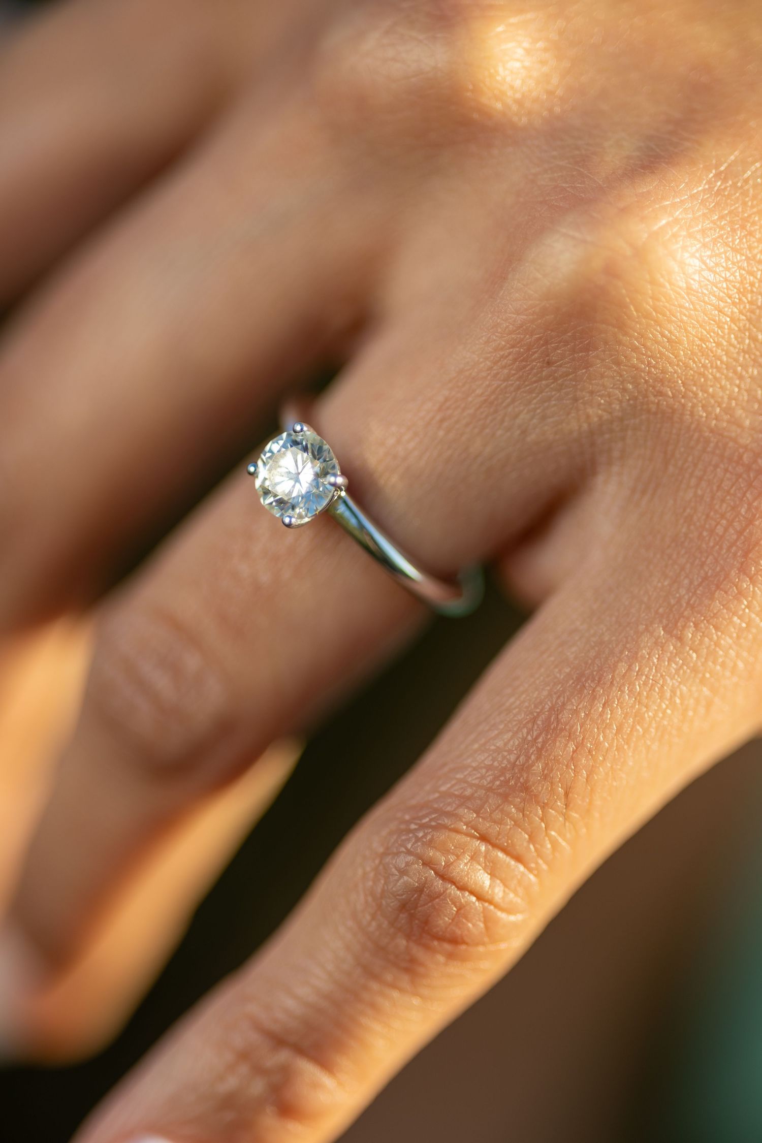 Close-up shot of a sparkling diamond engagement ring on a hand.
