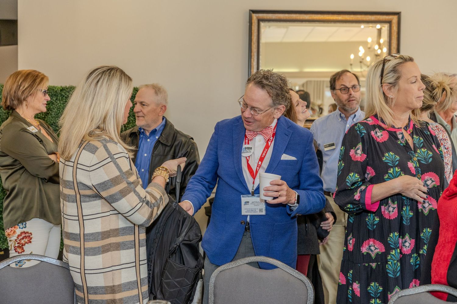 Business professionals mingling at a networking reception in formal attire.