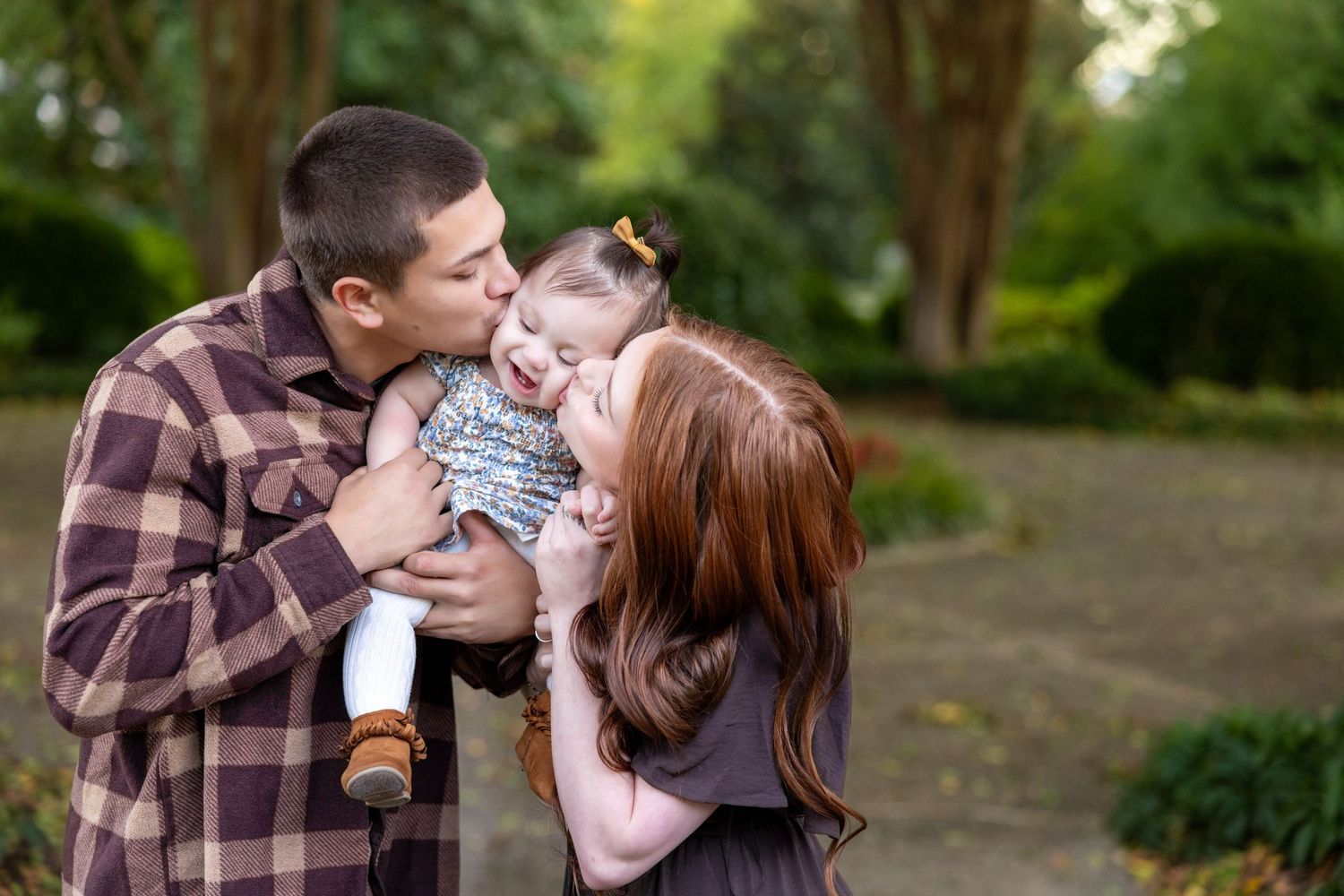 Intimate family photo session captured in a serene outdoor garden setting.