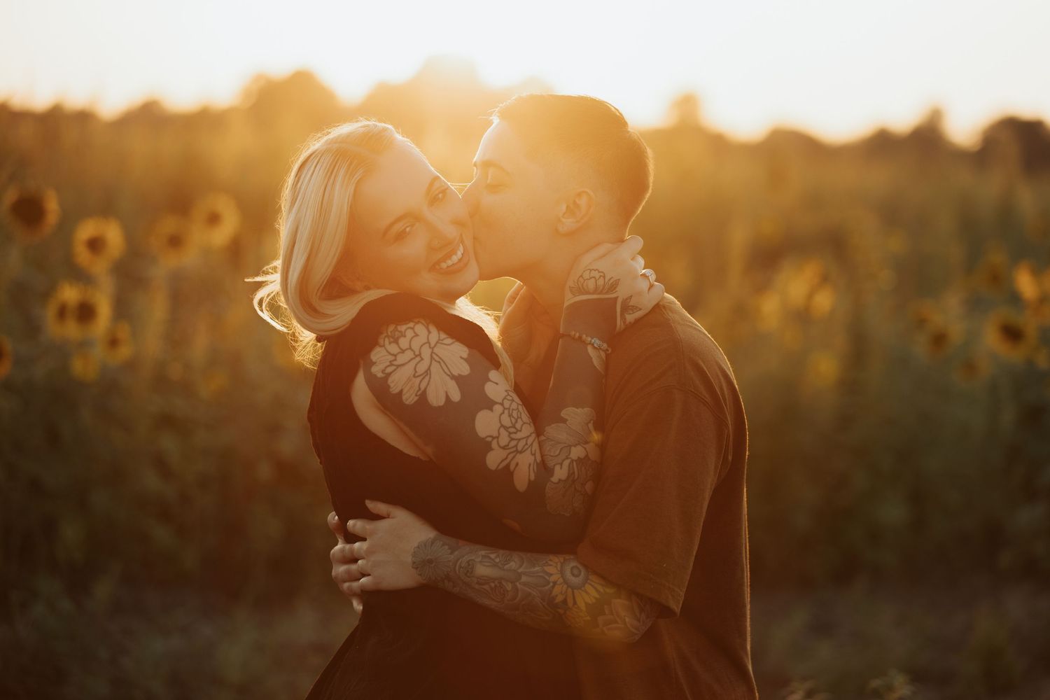 Ethereal sunset glow surrounds a tender scene in a sunflower field.
