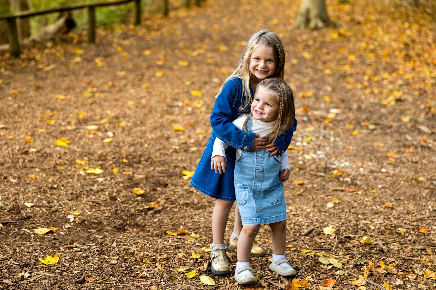 Candid family moments captured in autumn forest setting.