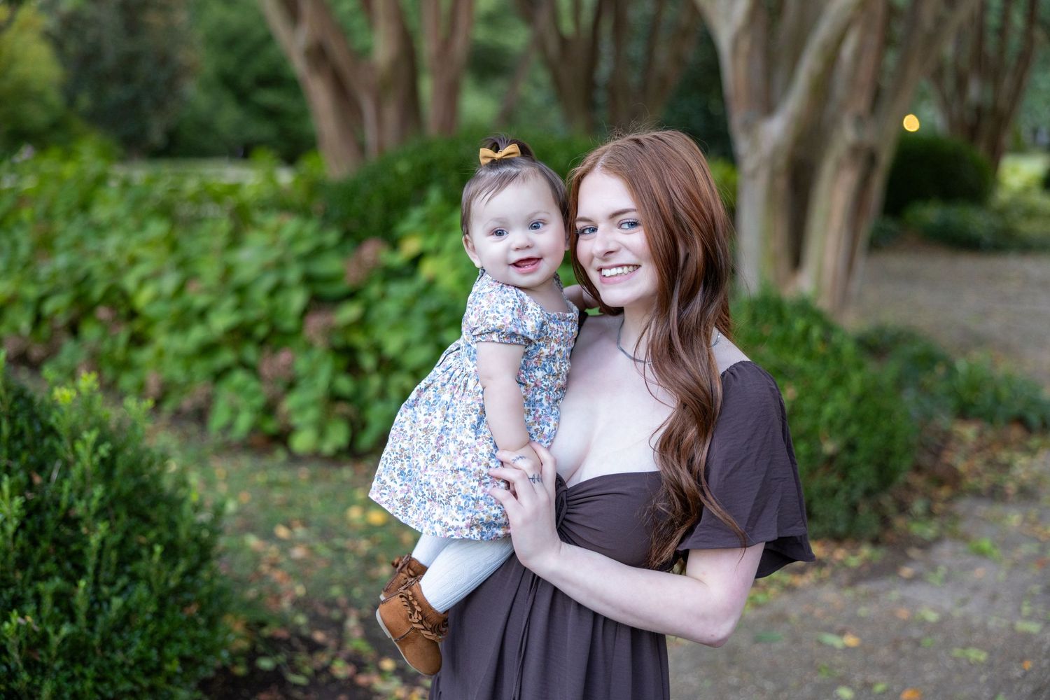 Sweet family portrait session in a peaceful garden setting with natural greenery.