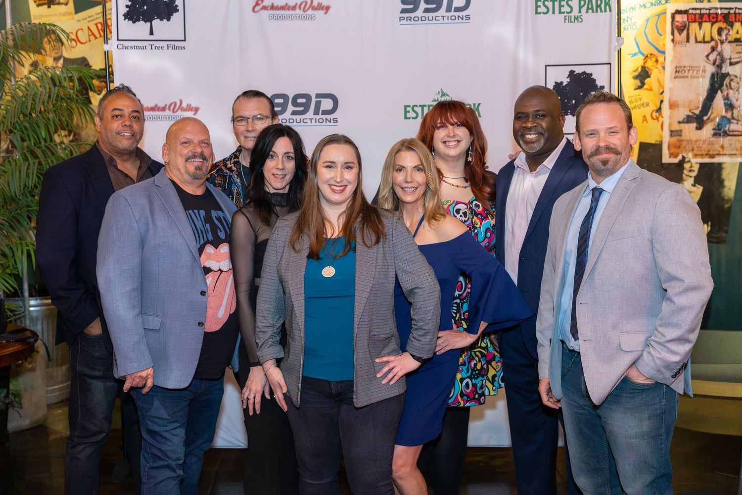 Group of professionals posing together at an Estes Park and SummitDay event with branded banners in the background.