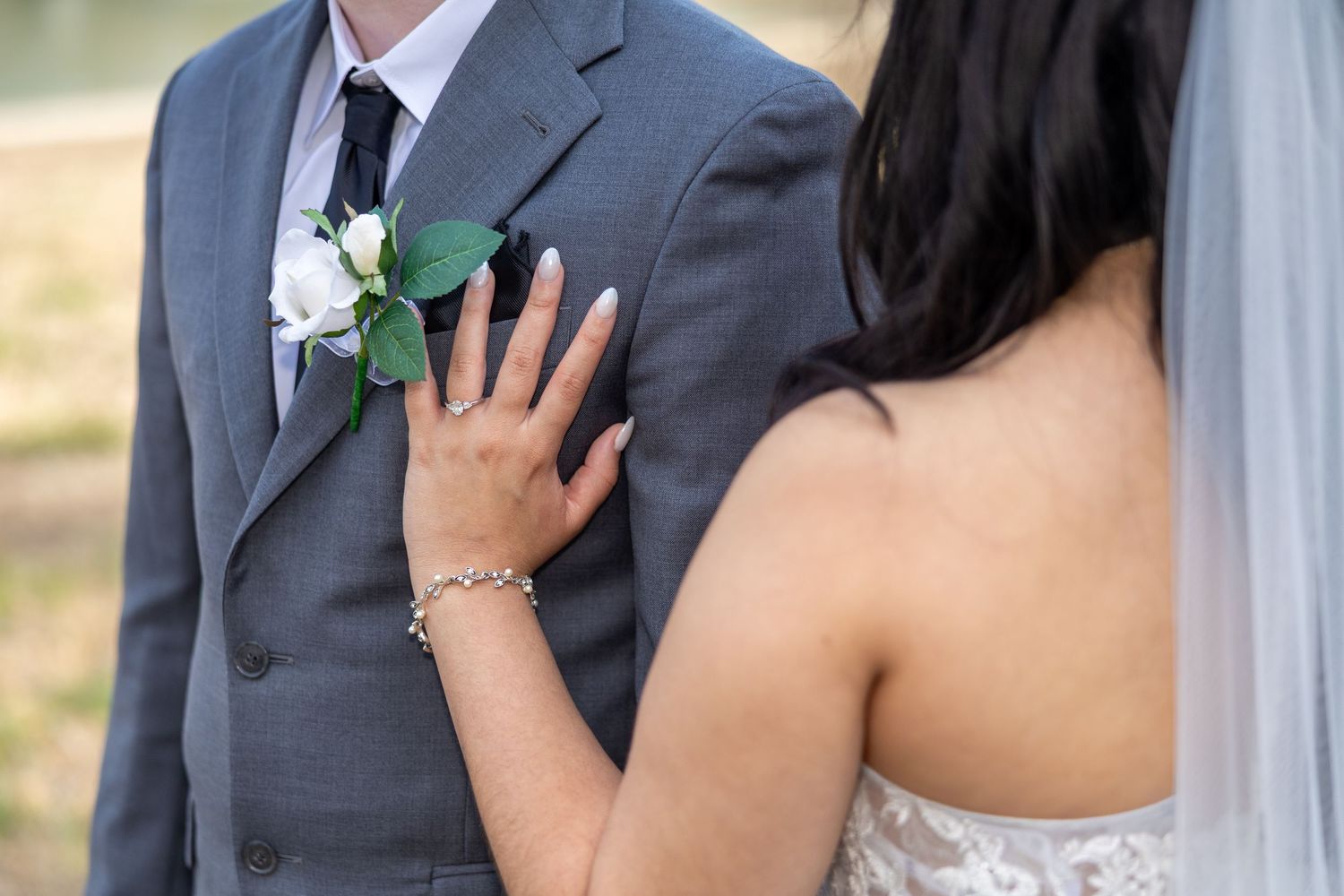 Bride and groom exchange vows while holding hands during an outdoor wedding ceremony.