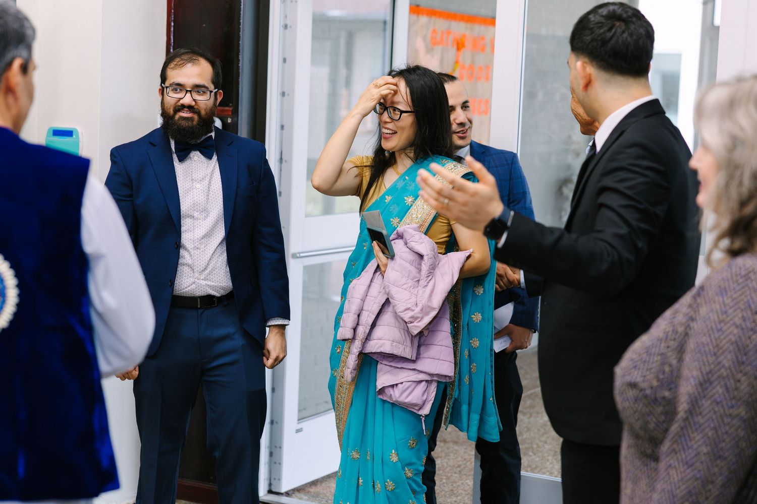 Formal event guests mingling and socializing in an indoor reception area.
