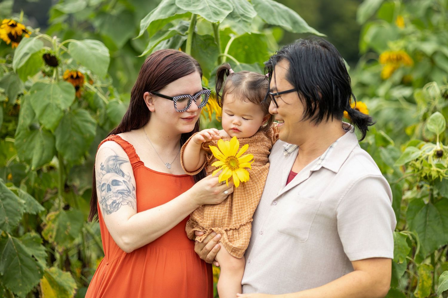 Tender family moment captured among blooming sunflowers in a garden setting.