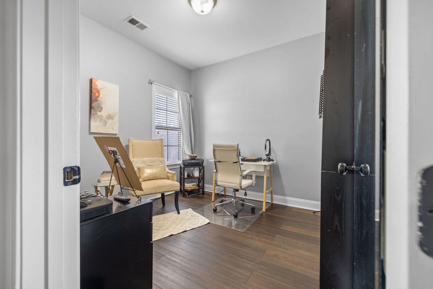 Interior view of a modern apartment with hardwood floors and white walls showing multiple rooms and hallway spaces.