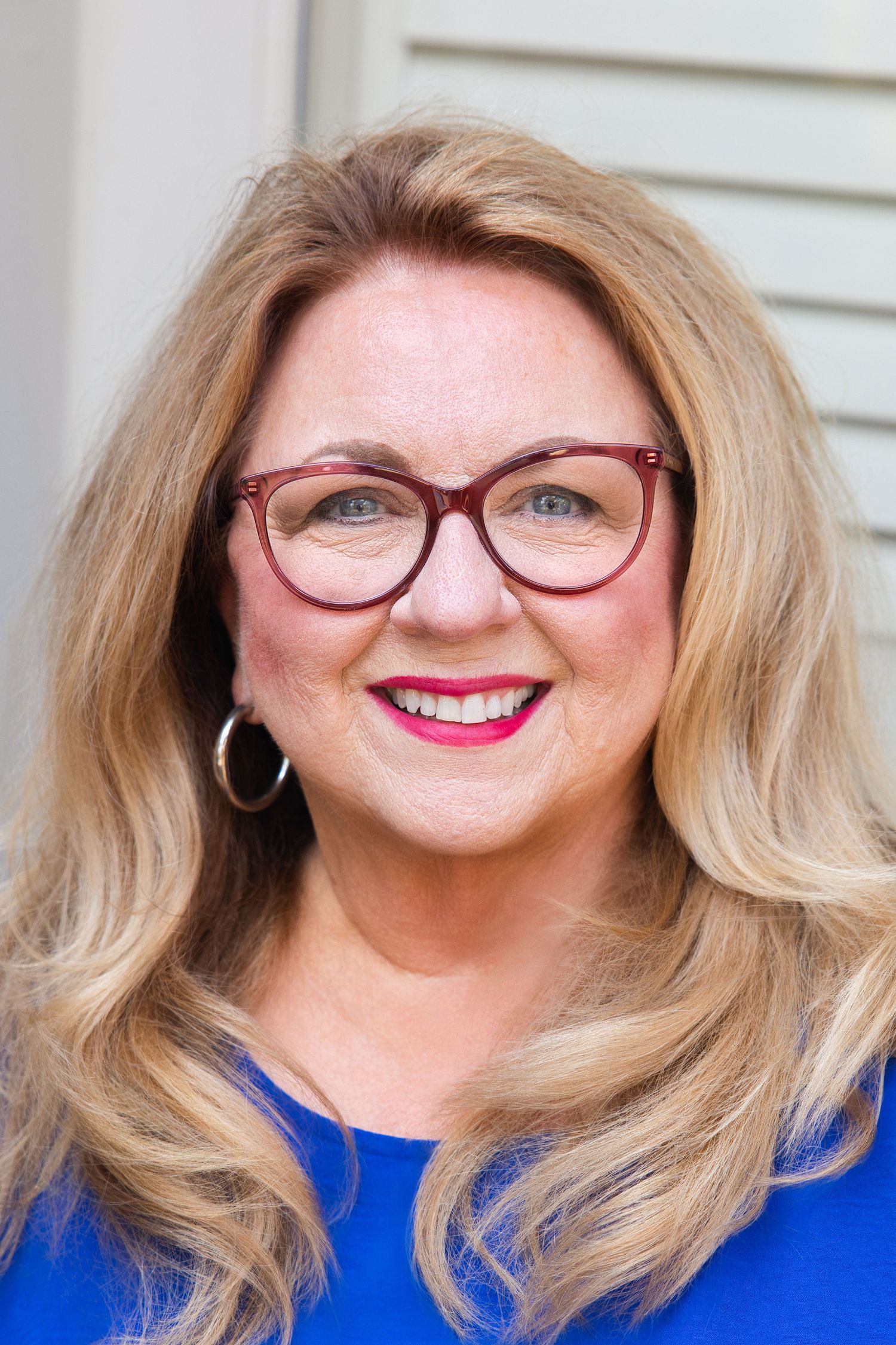 Professional portrait series featuring bright smiles and red glasses against white background.