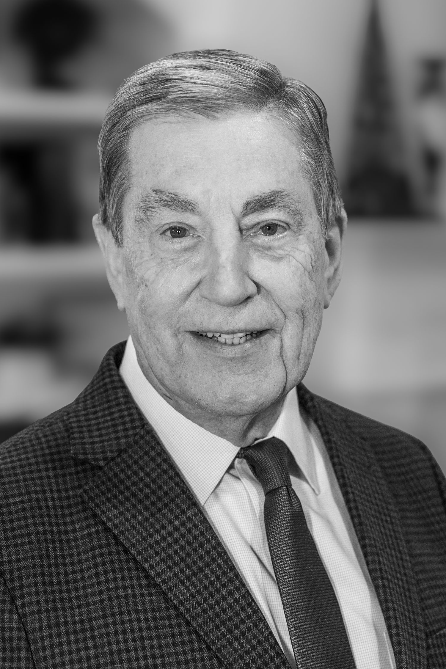 Black and white portrait of a senior gentleman in a suit and tie.