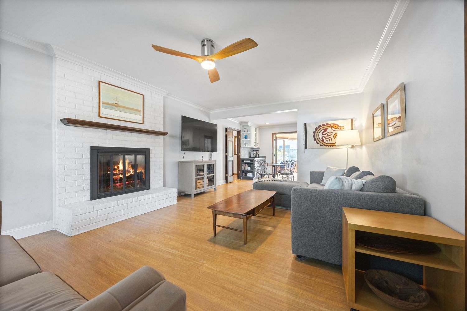 Contemporary living room with fireplace, wood floors, and comfortable gray seating.