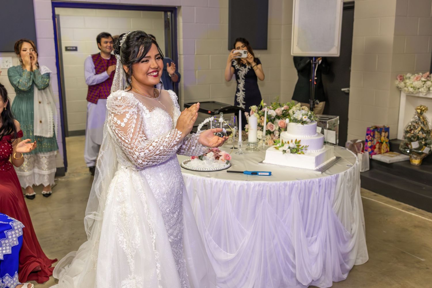 Wedding reception hall decorated with purple and white linens and elegant table settings.