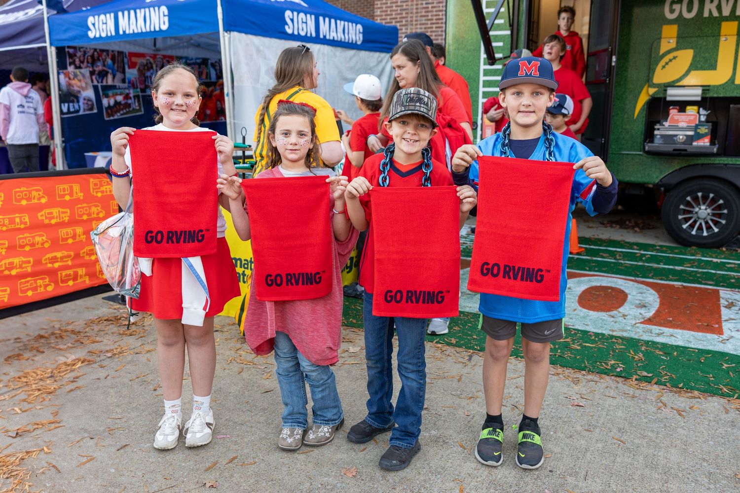 Children line up holding signs at a community event.