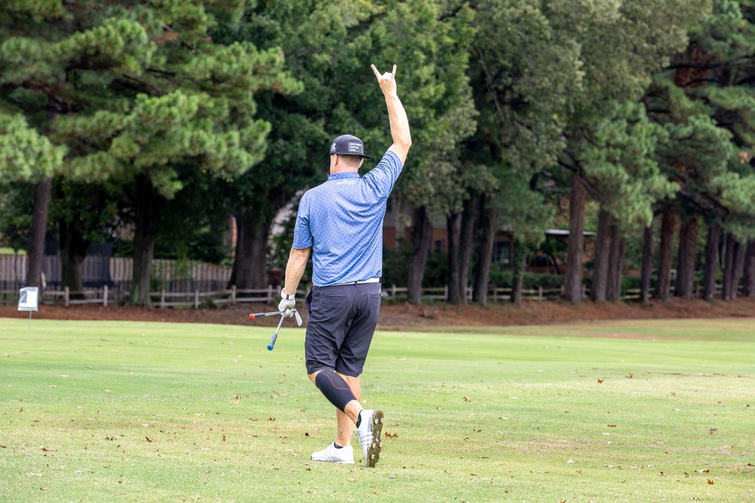 Golfers practicing their swings on a lush green course.