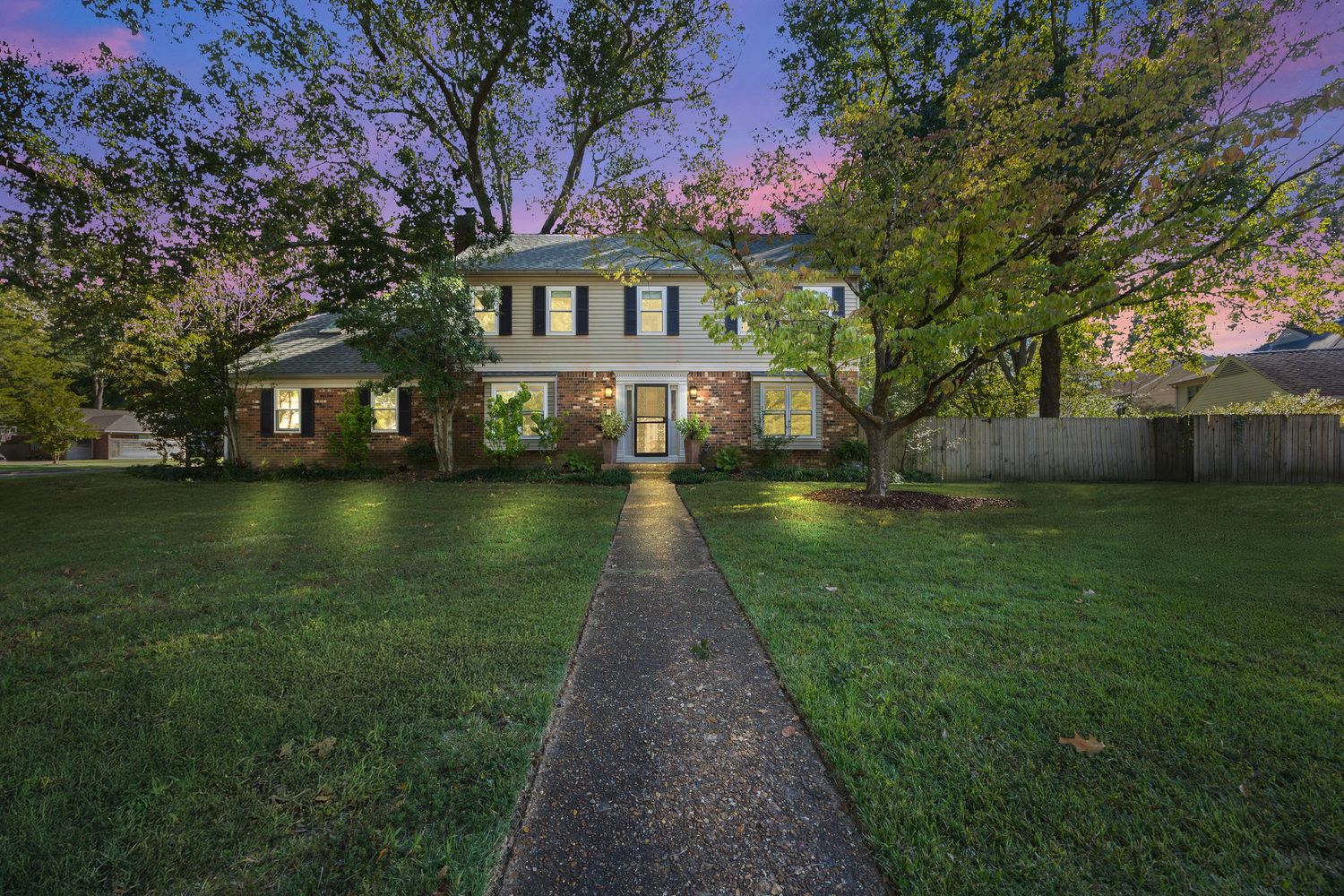 Panoramic view of a residential neighborhood with trees and houses at dusk.