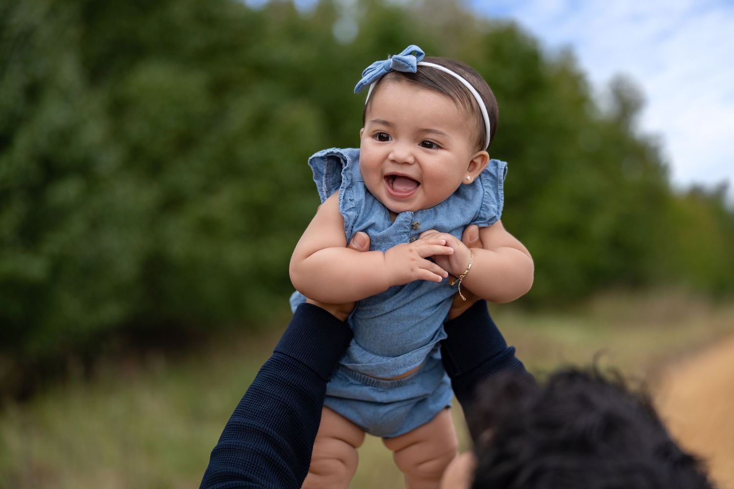 A candid outdoor photoshoot showing playful moments on a sunny day with greenery in background.
