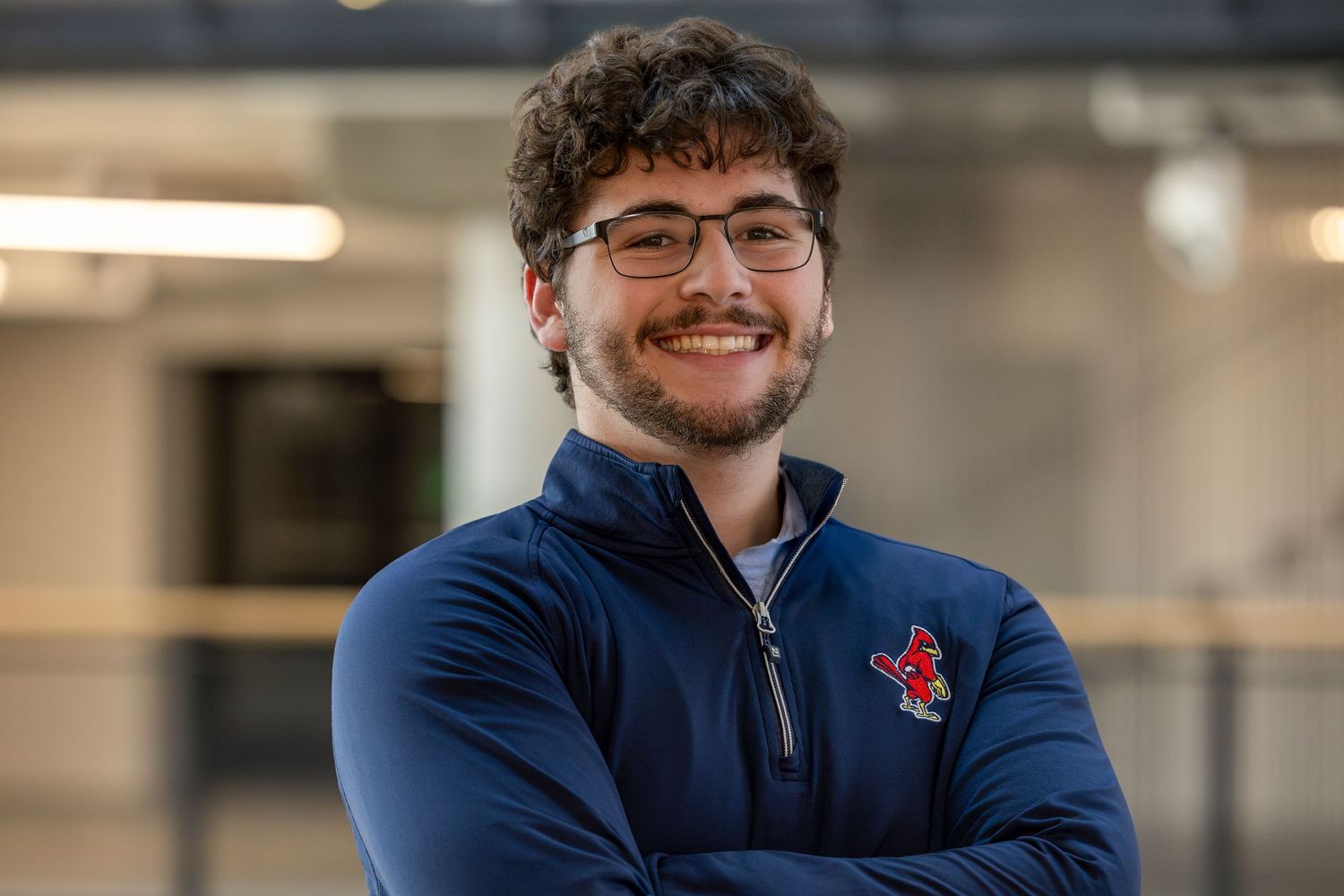 Professional headshots of someone in a blue shirt smiling against a blurred office background.