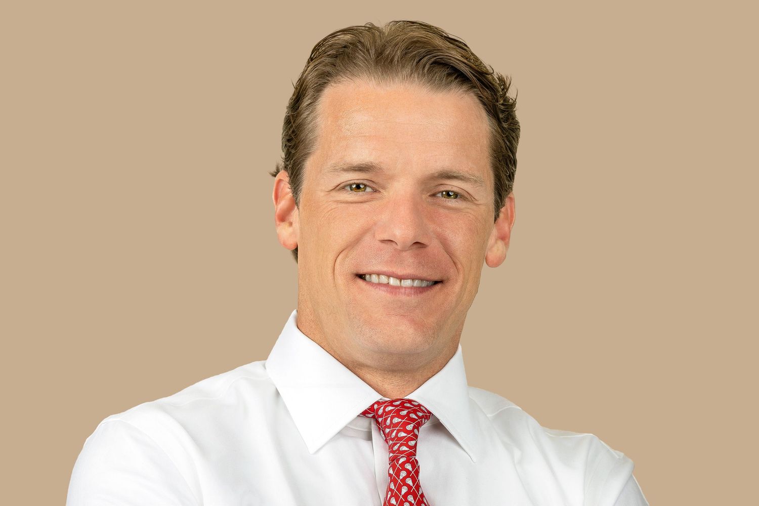 Professional headshots of executive in white shirt and red tie against neutral backdrop.