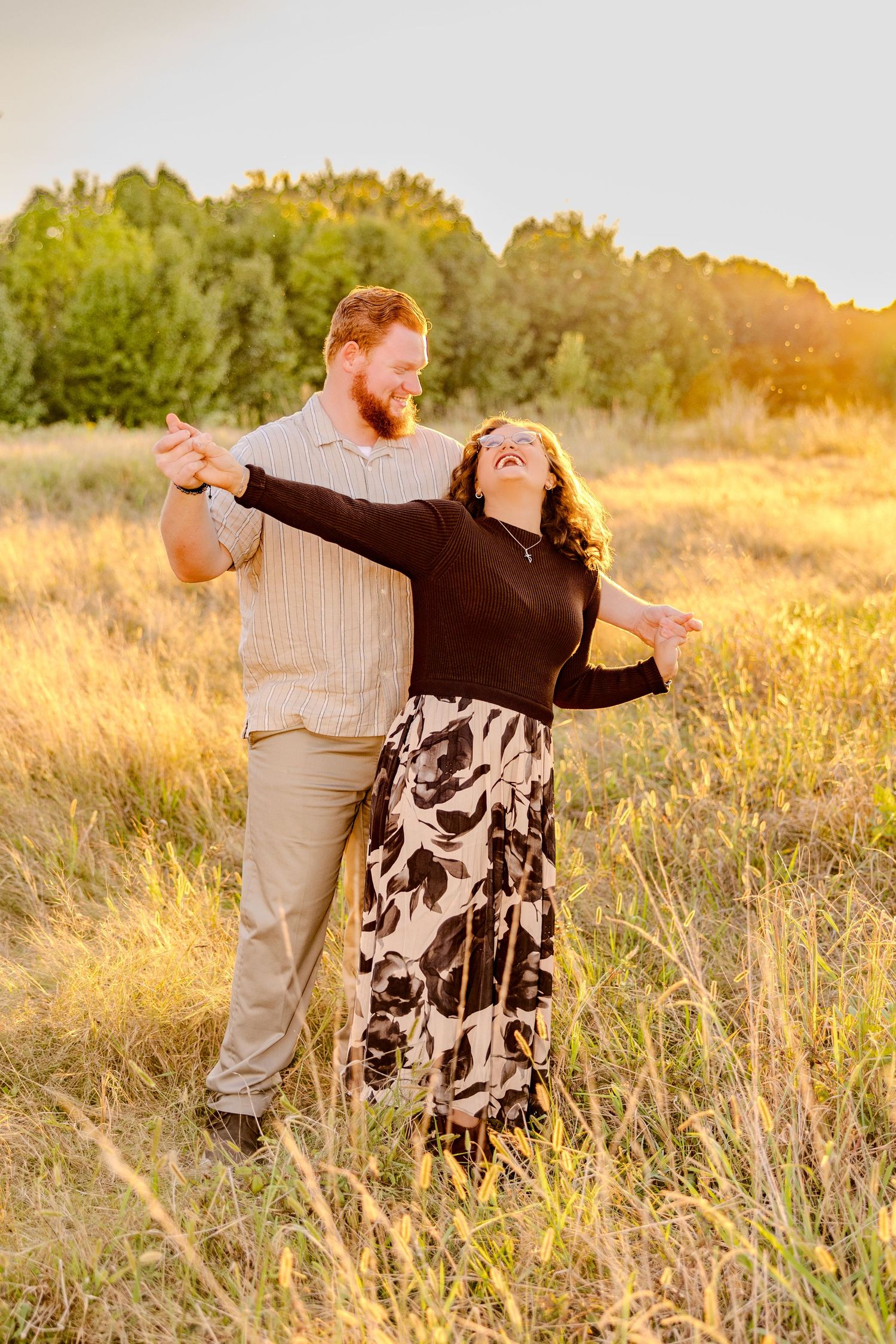 Playful dance moves captured in meadow during sunset photoshoot.