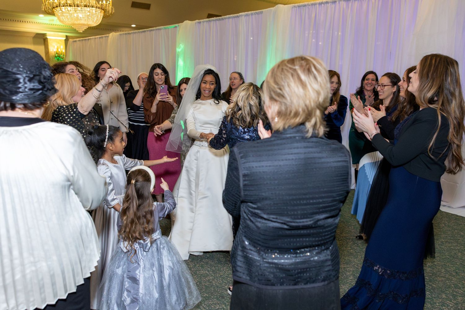 Wedding reception guests dancing and celebrating in an elegant ballroom.
