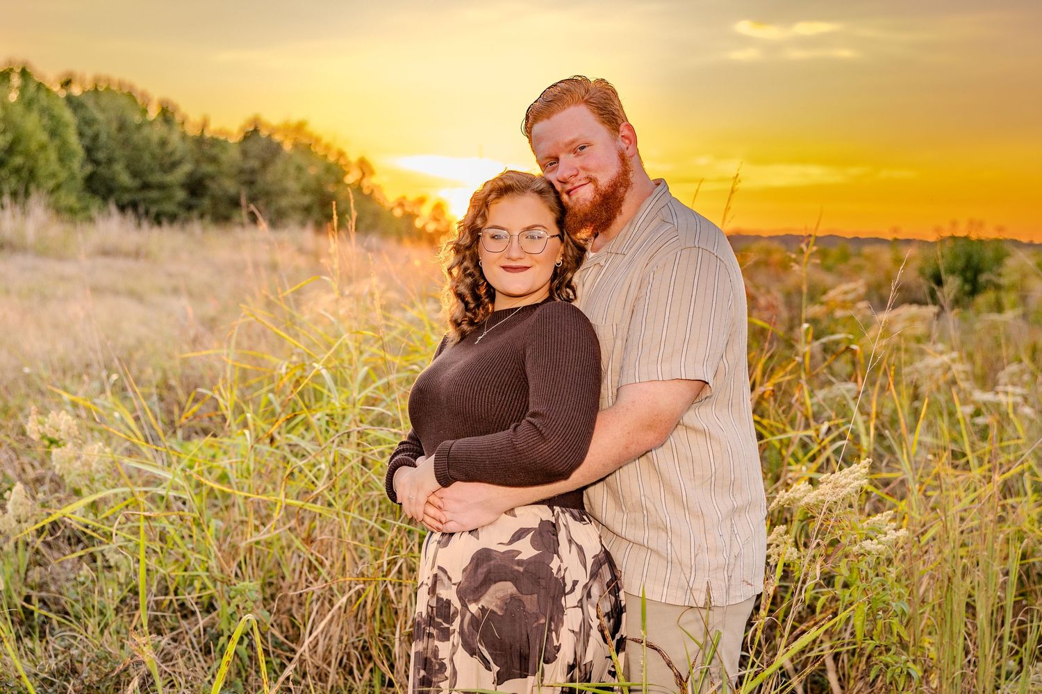 Romantic sunset photoshoot in a meadow with warm golden hour lighting.