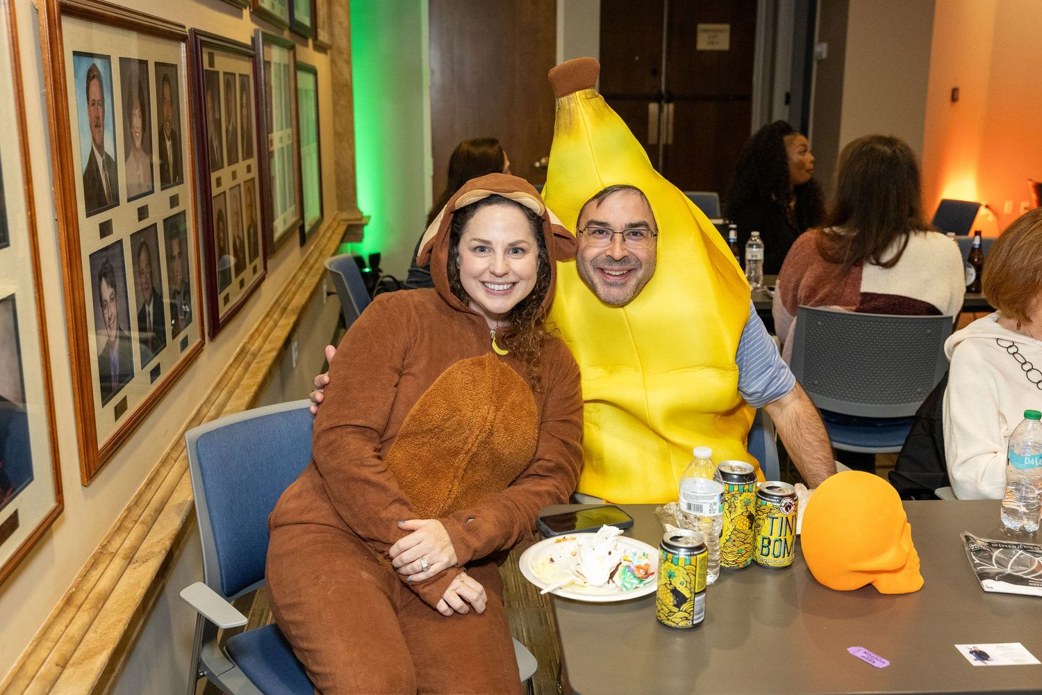 People enjoying a festive Halloween party with colorful decorations and costumes in an indoor venue.