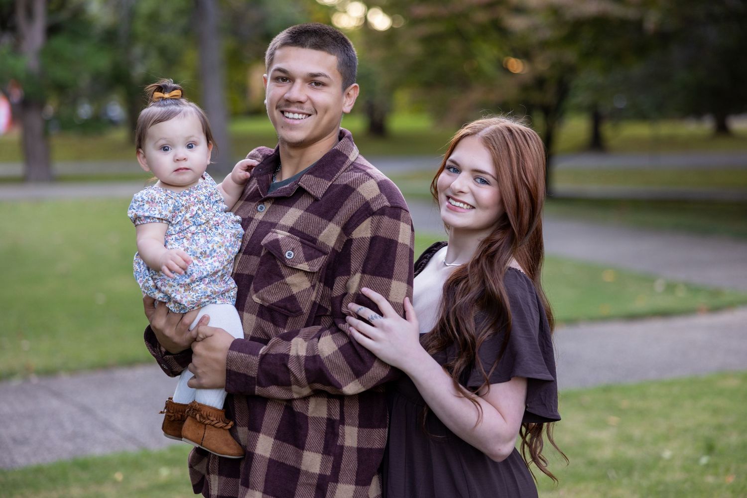 Joyful outdoor family portrait session in park with natural lighting.