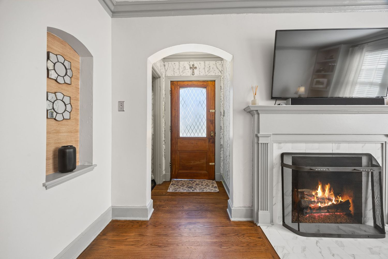 Interior view of entryway with decorative wall niches and gas fireplace.
