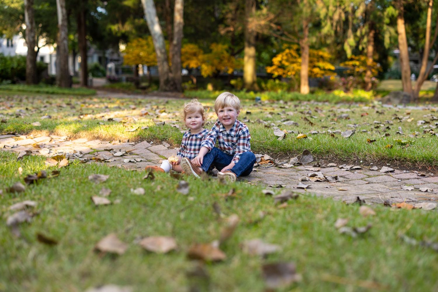 Group enjoying autumn day among fallen leaves in backyard.