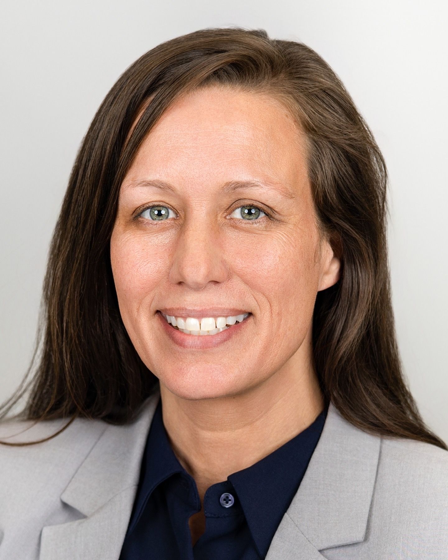 Professional headshots with grey blazer against white background.