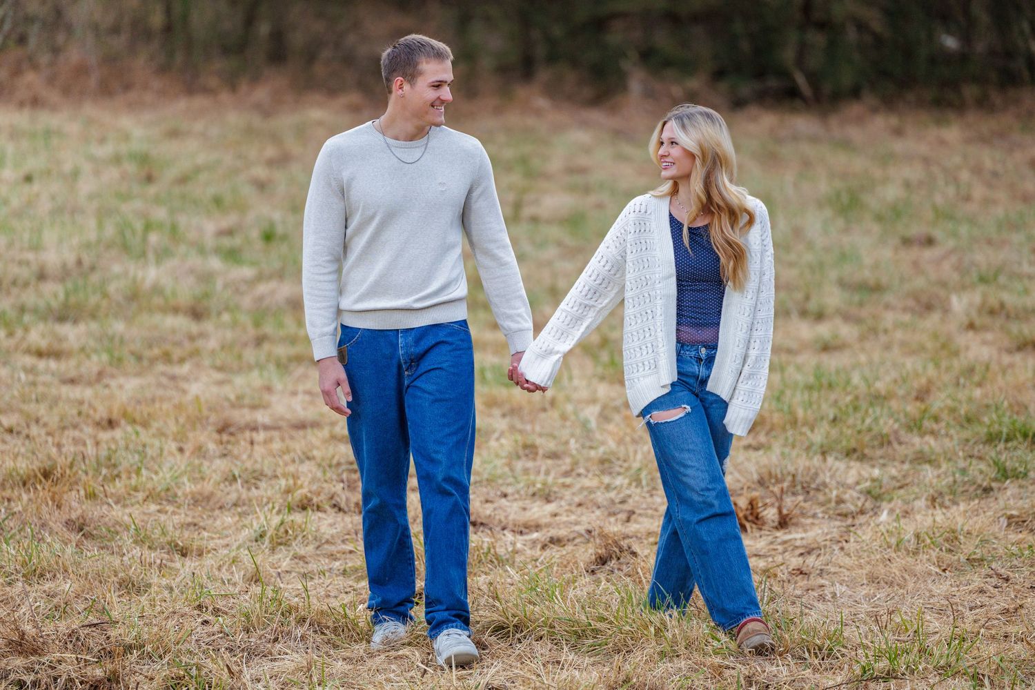 A couple enjoying a casual moment together on a grassy hill in matching denim.