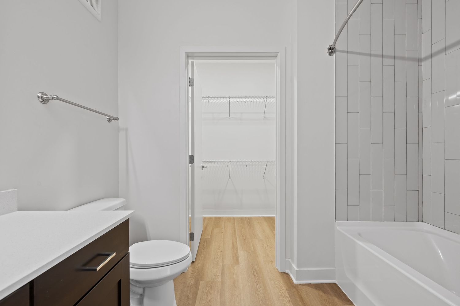 Clean white bathroom with modern fixtures, tiled walls and glass shower enclosure.