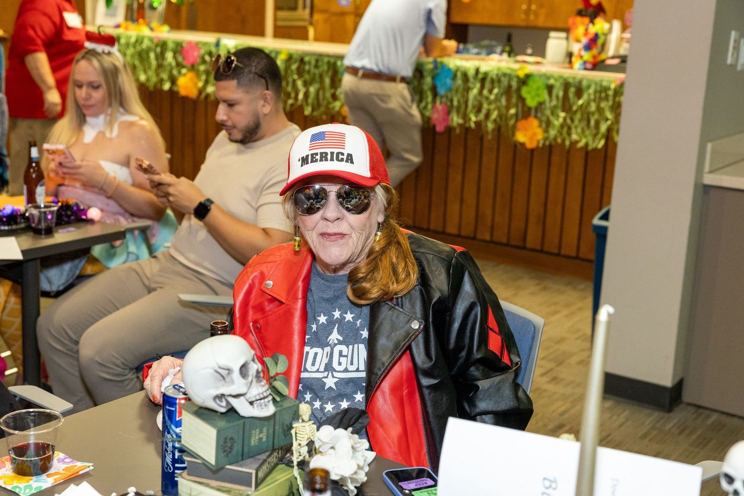 People in casual attire and costumes socializing at an indoor community event.
