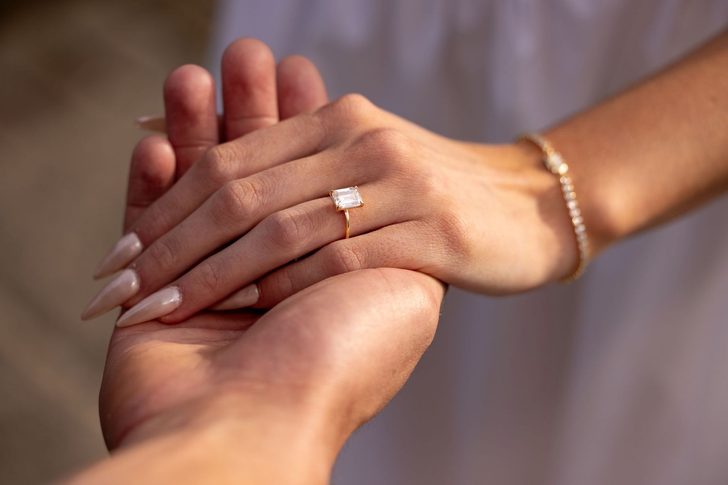 Close-up view of hands with manicured nails performing a professional hand massage technique.