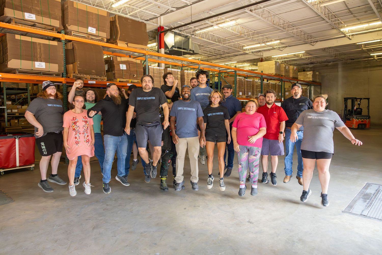 Group photo of warehouse team members standing together in distribution center.