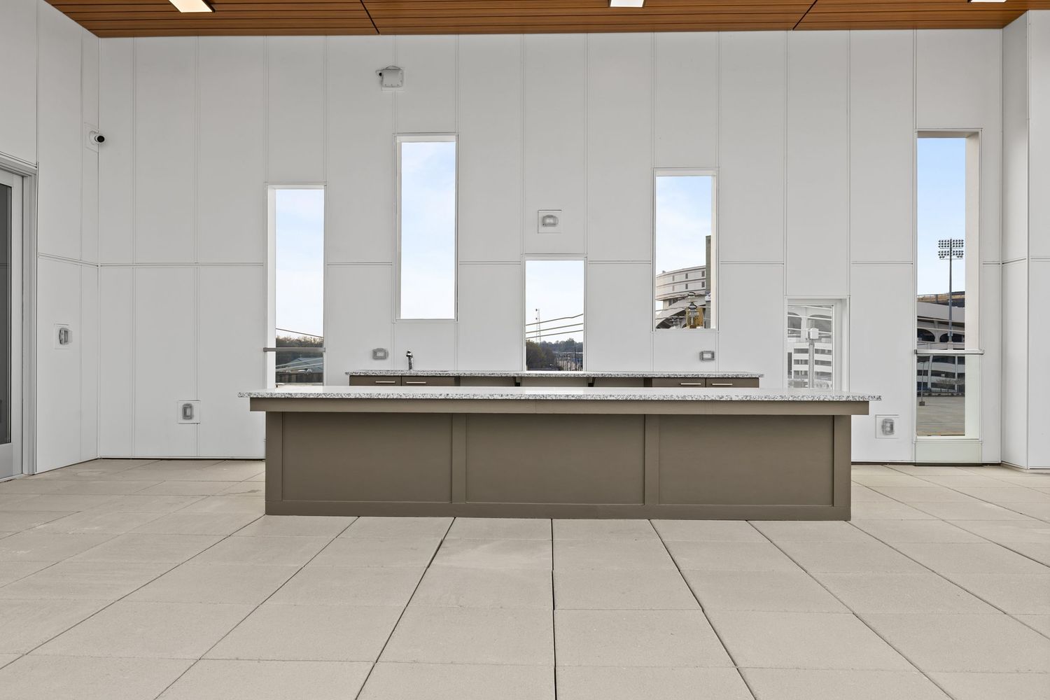 Contemporary open-concept living space with wood ceiling details and large windows.