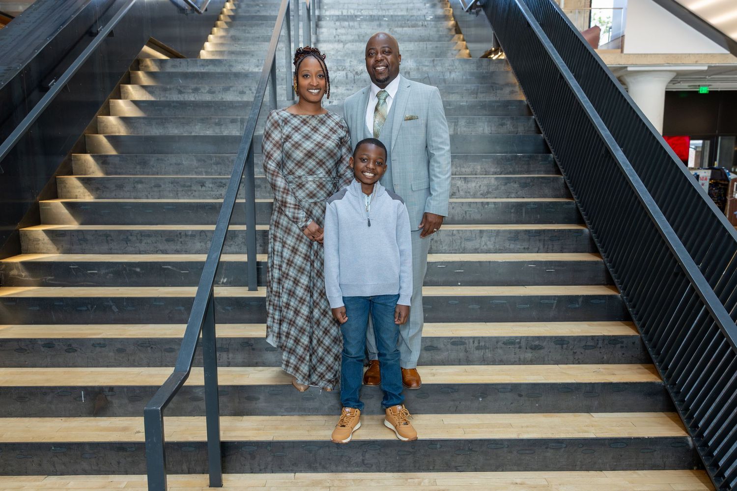 Family photo session on modern black and wood staircase.