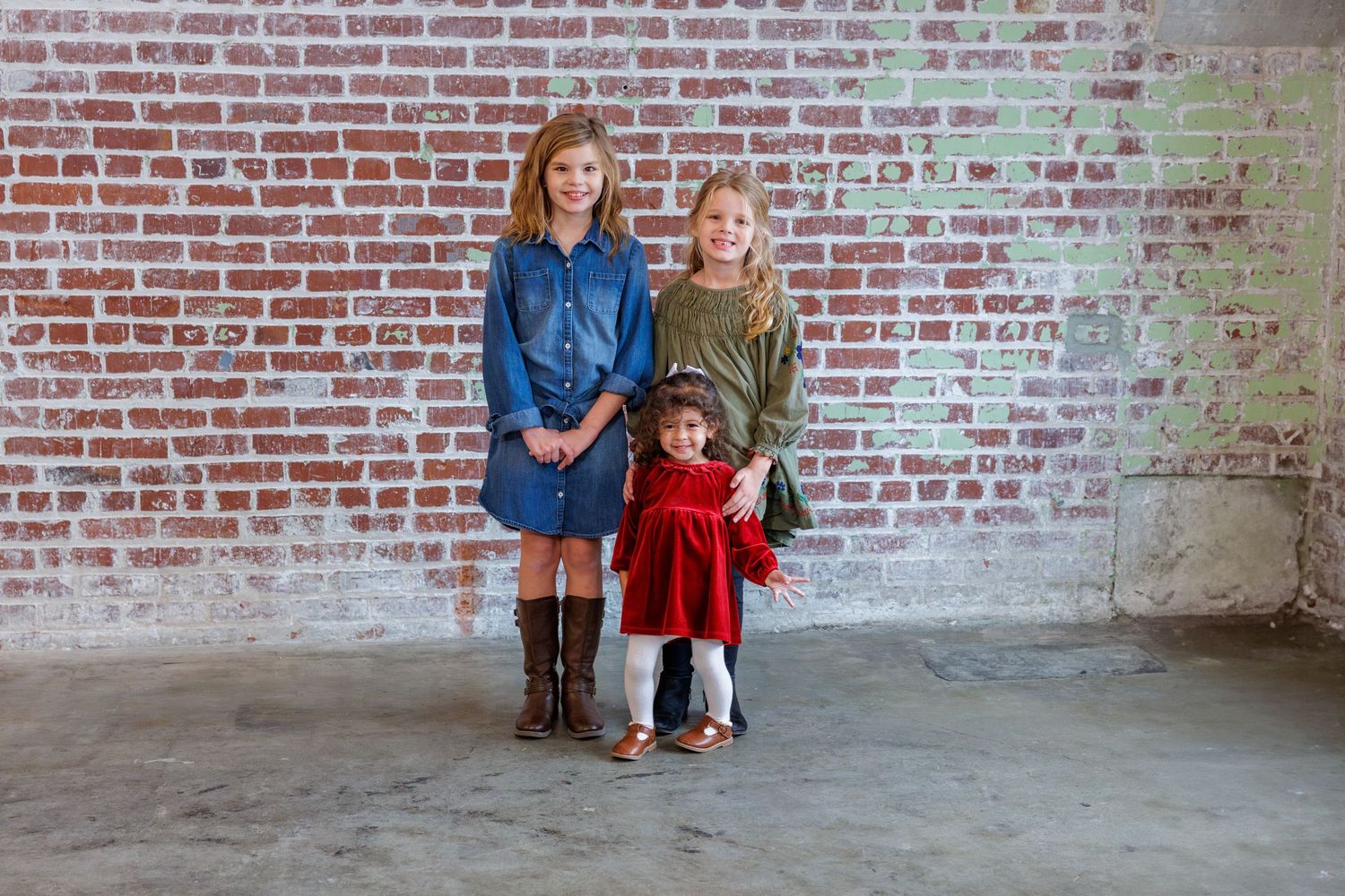 Multiple family portraits arranged in sequence against a weathered brick wall backdrop.