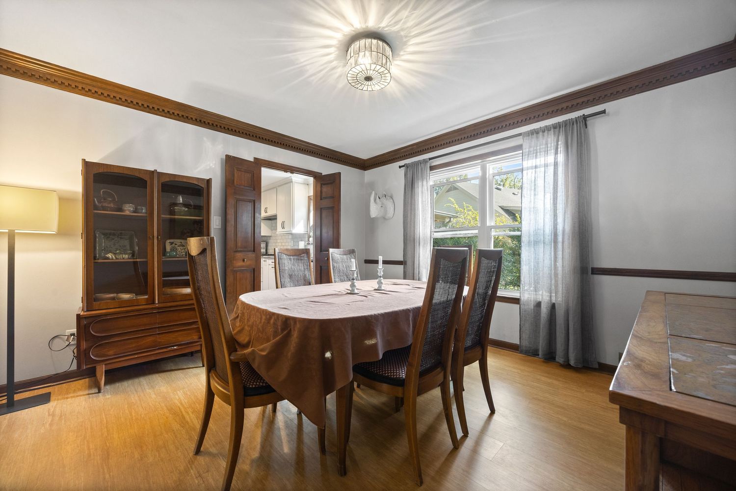Formal dining room with wood trim, chandelier lighting and traditional furniture.