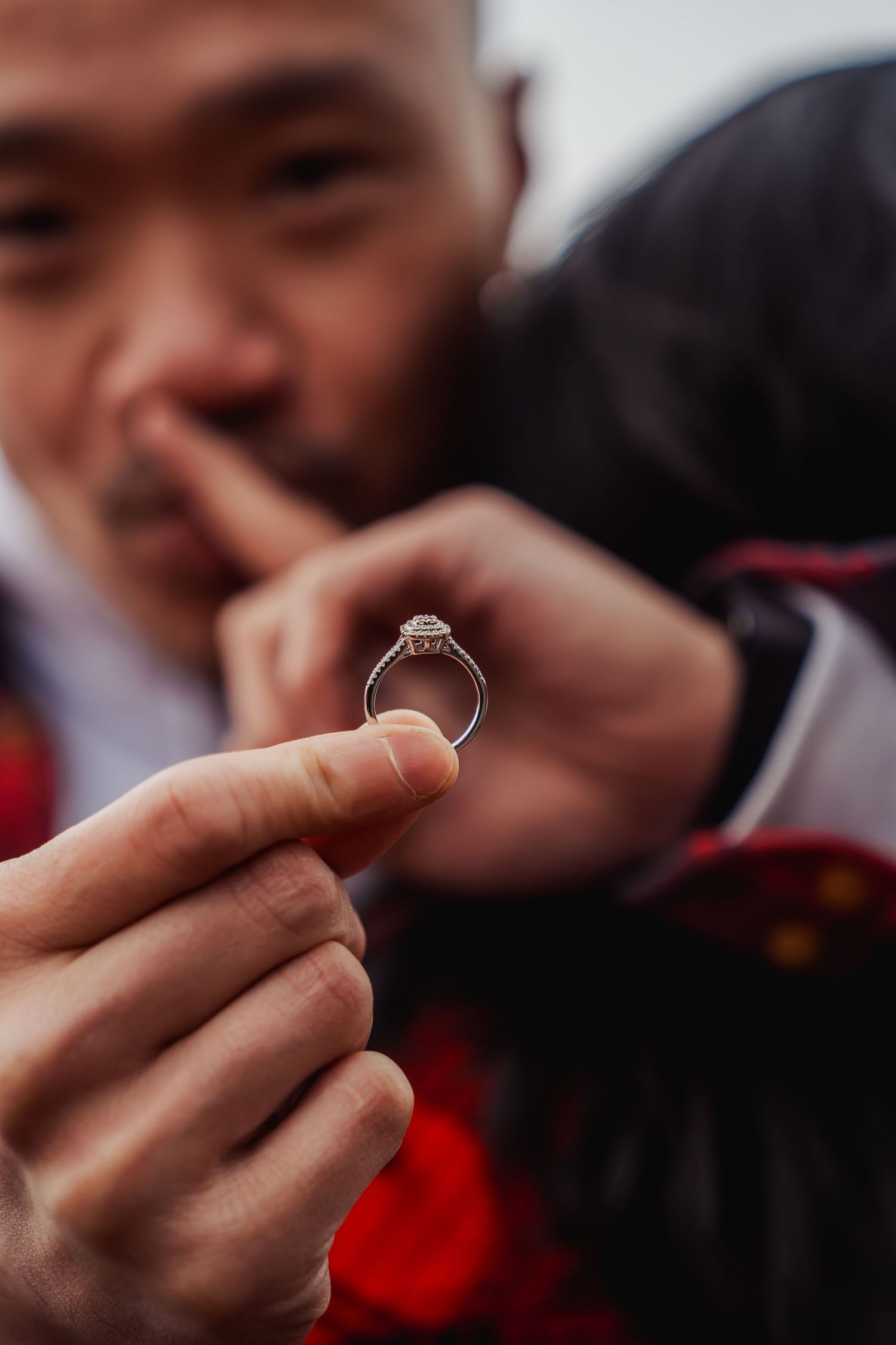 Close-up shot of hands holding a sparkling engagement ring.