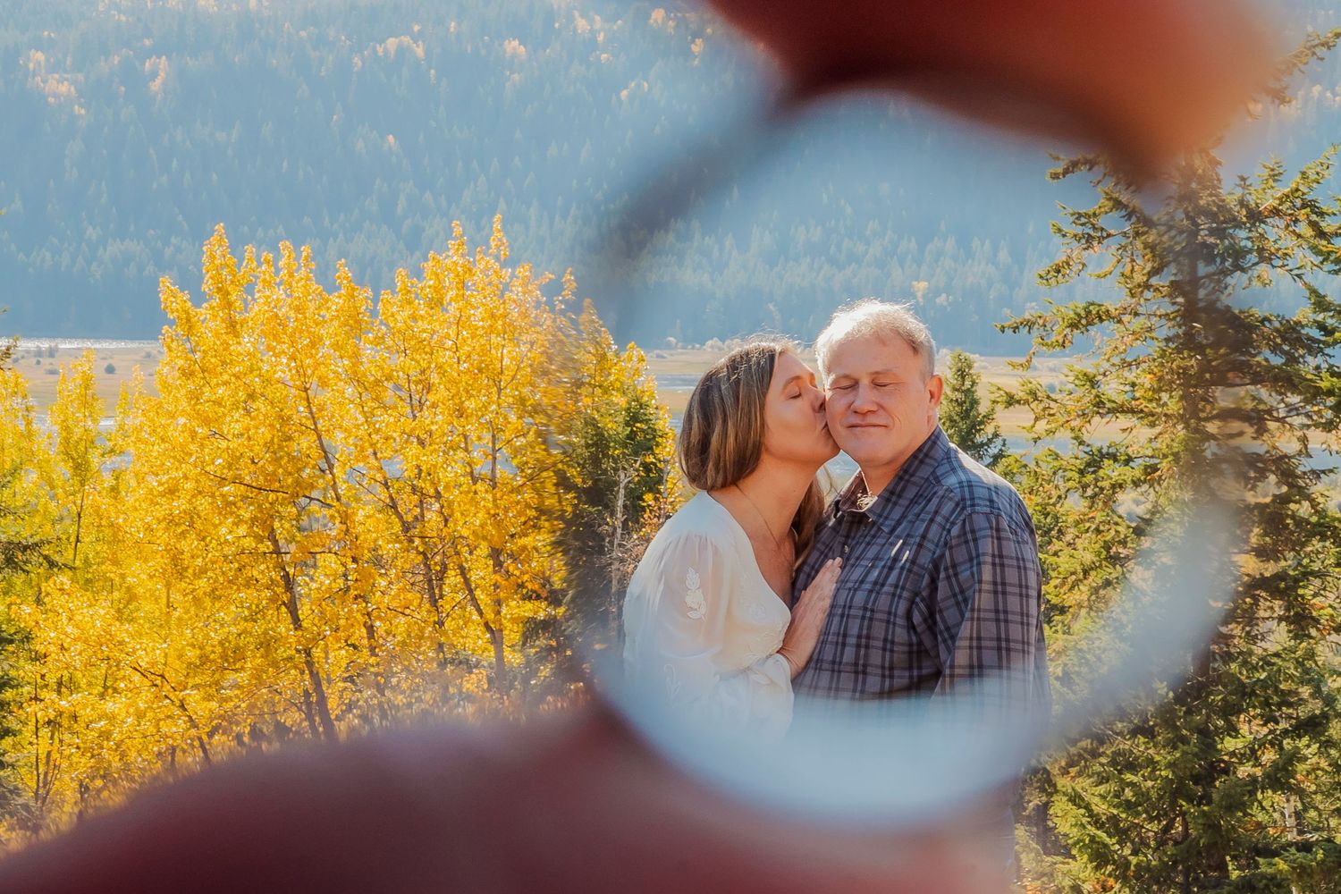 A tender autumn moment captured between a couple with golden aspen trees in the background.