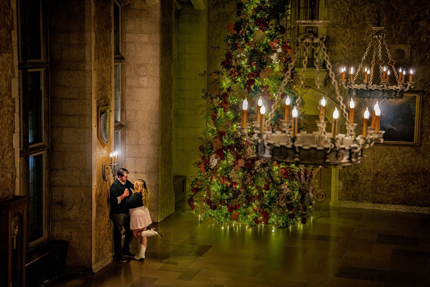 Stone archway decorated with twinkling lights and greenery creating romantic ambiance.