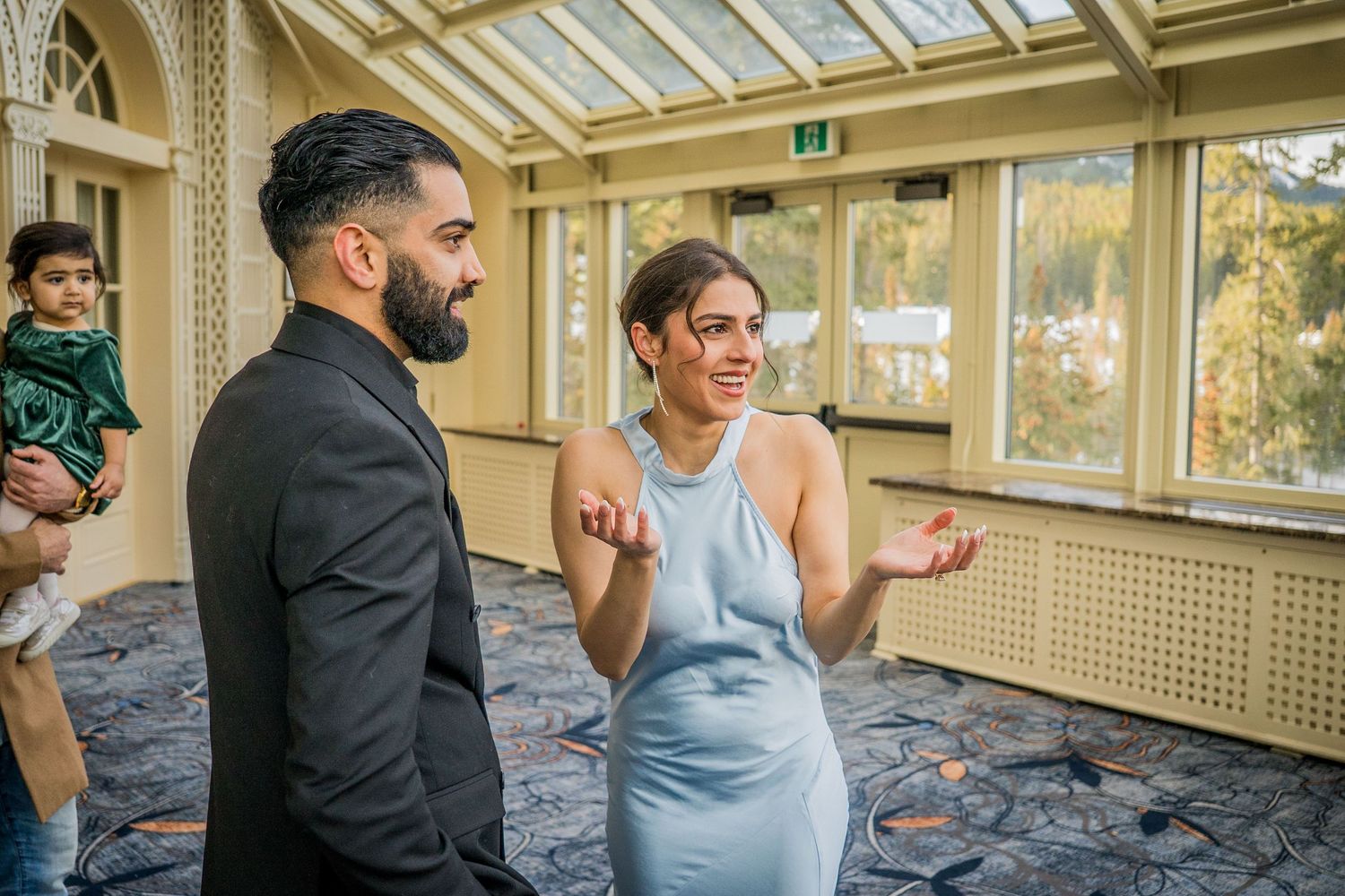 People dancing together in a sunlit room with large windows and wooden floors during a social dance class or event.