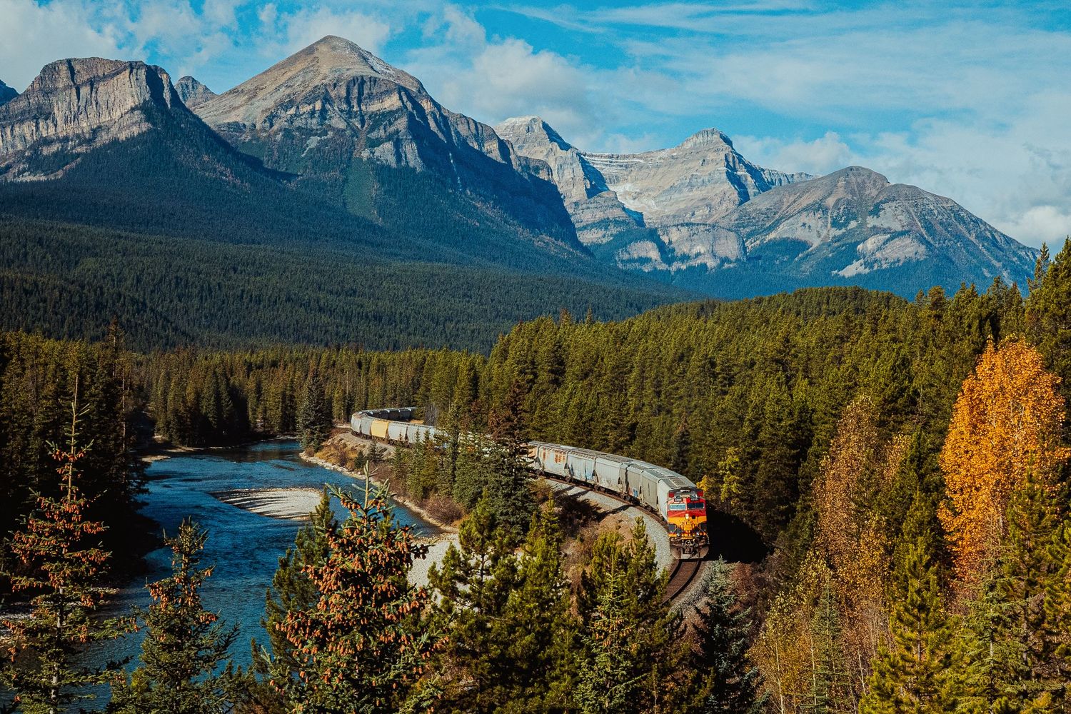 A scenic mountain panorama in Banff National Park showcases snow-capped peaks, autumn forests and turquoise lakes.
