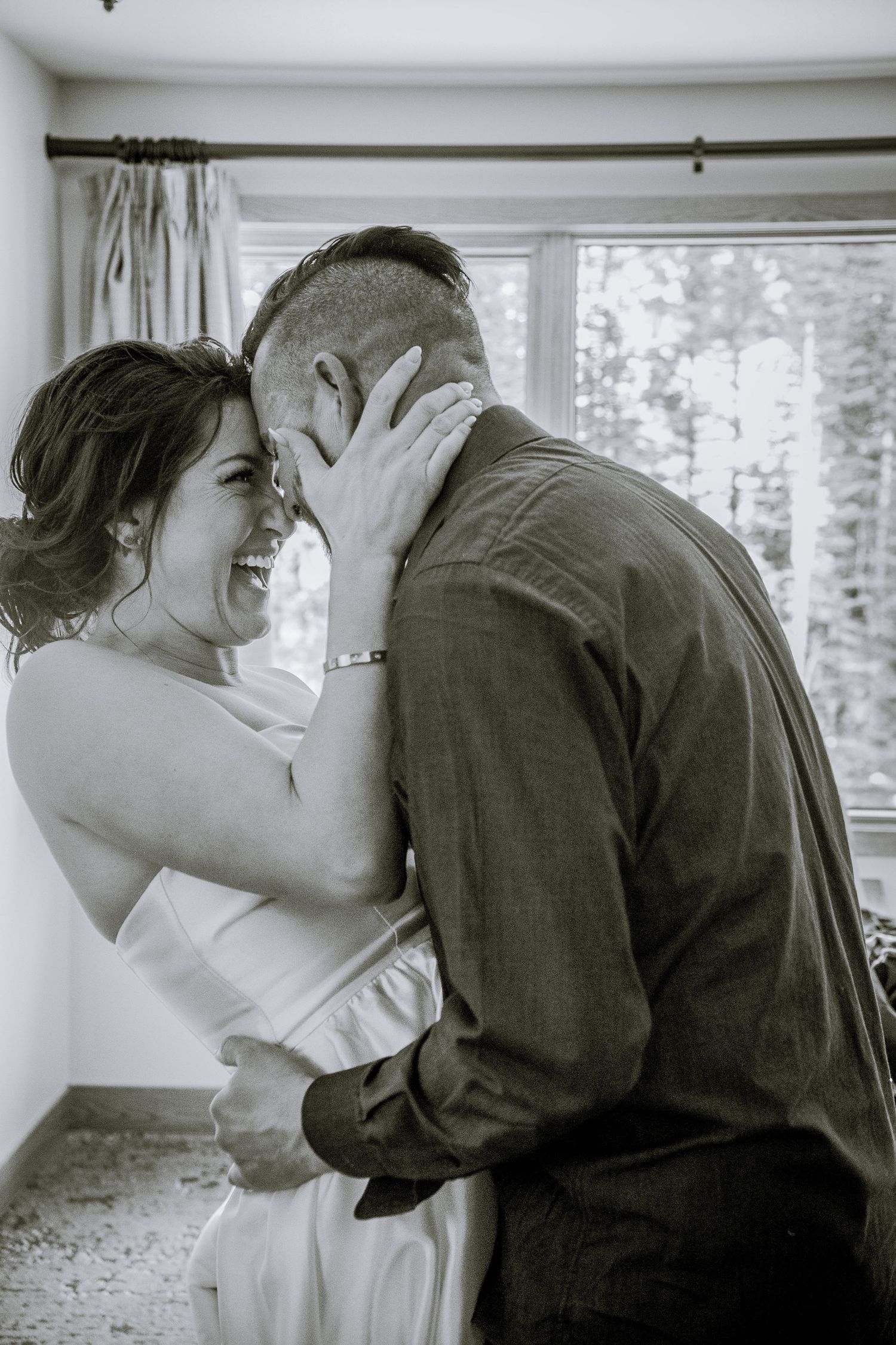 An intimate black and white moment shared between a couple during a wedding celebration.