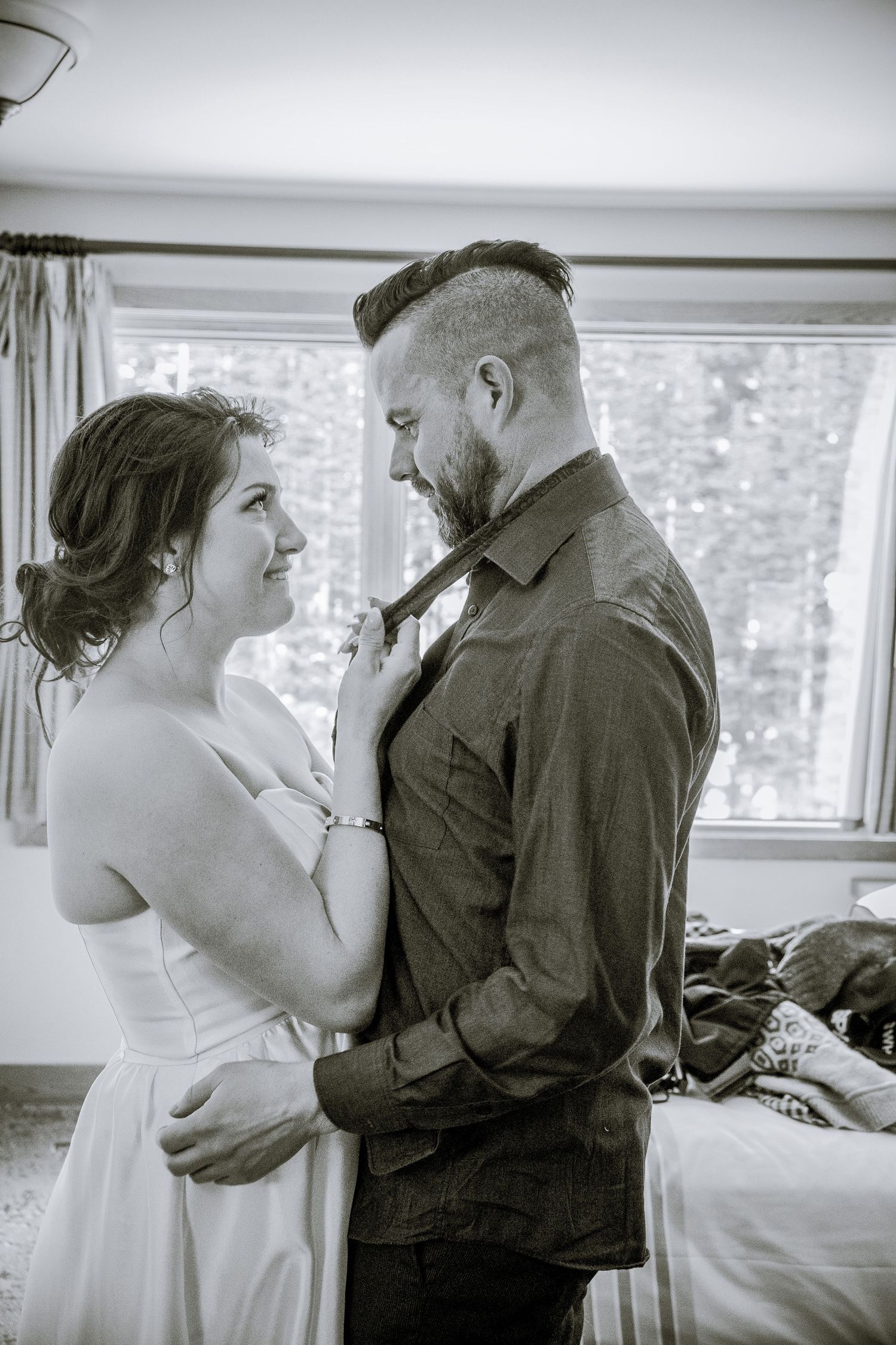 A tender moment captured in black and white between a couple in formal attire.