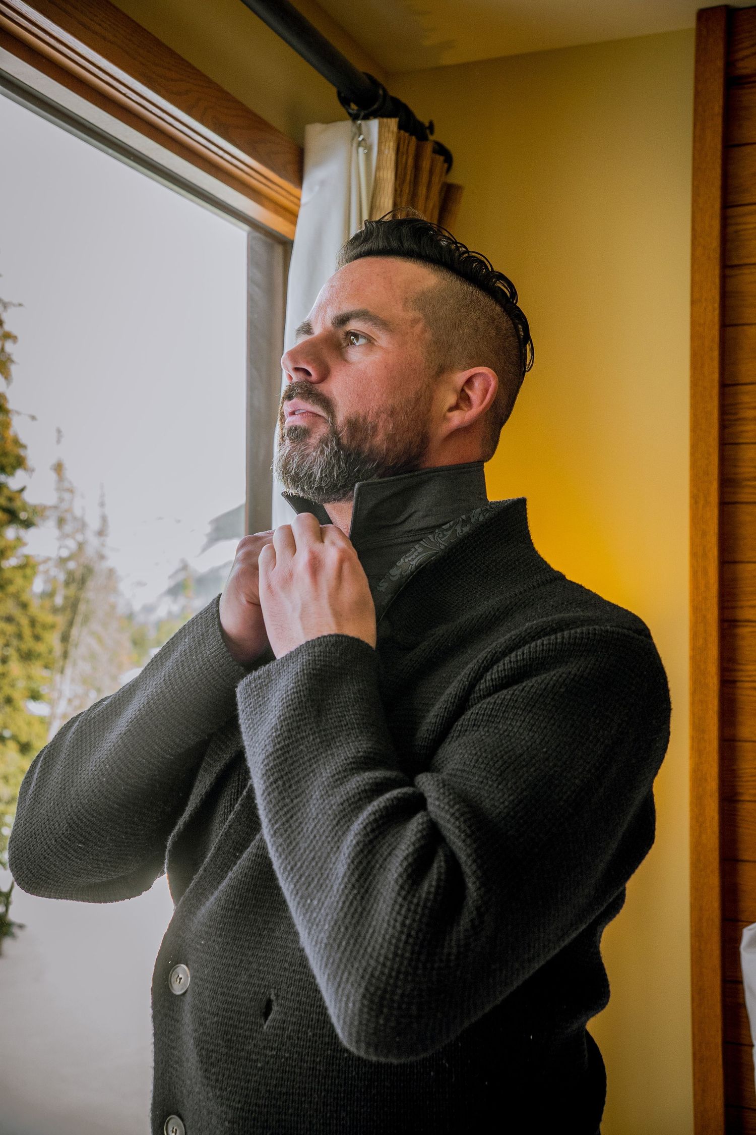 Person in a black sweater gazes thoughtfully out a window while touching their face in a triptych composition.