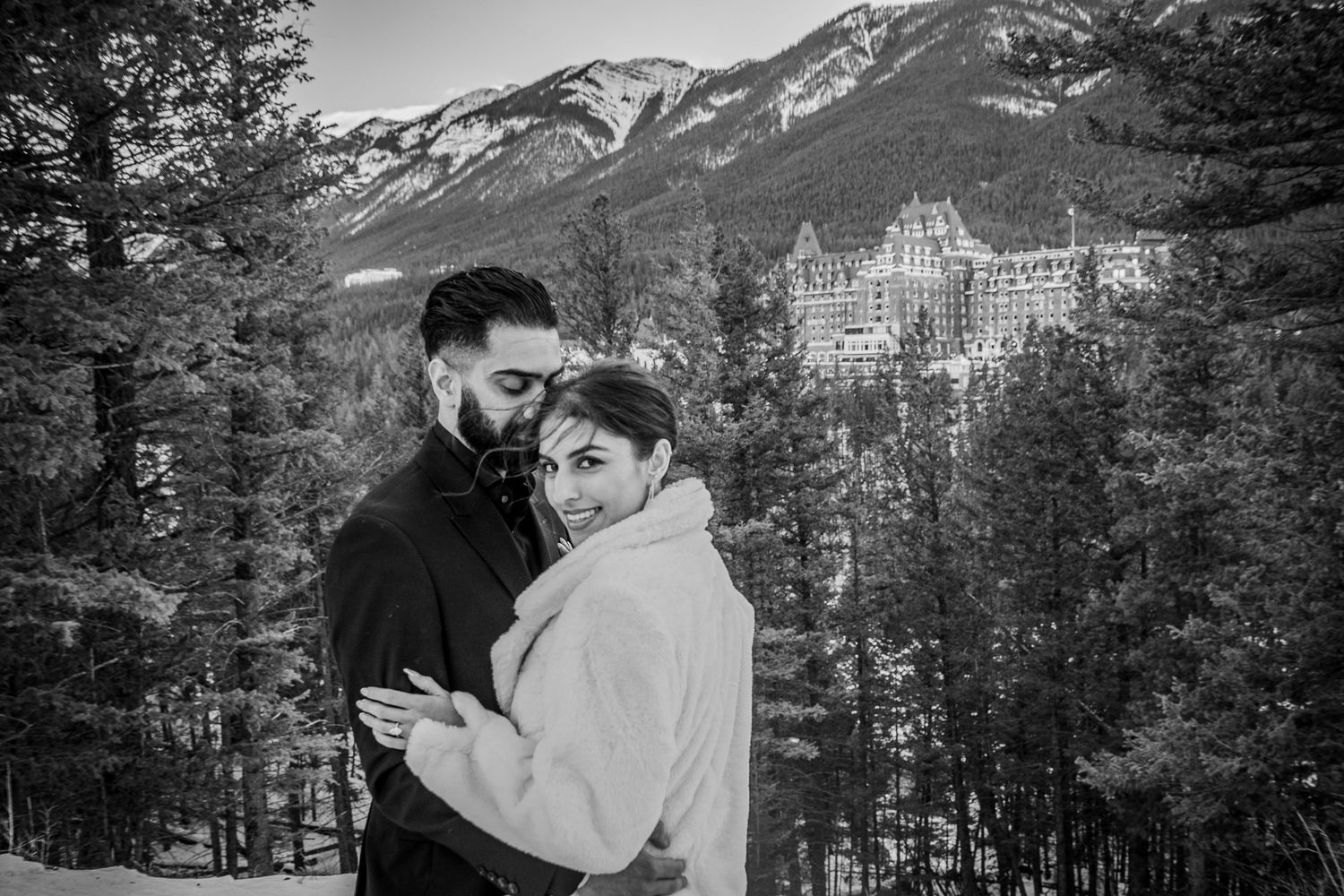 A romantic winter scene with the majestic Fairmont Banff Springs Hotel nestled in the snowy Canadian Rockies.