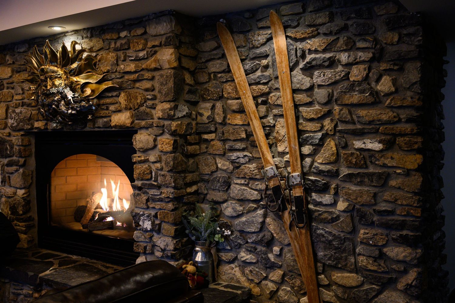 Rustic stone wall interior with illuminated fireplace nooks creating a warm, cozy ambiance in evening light.