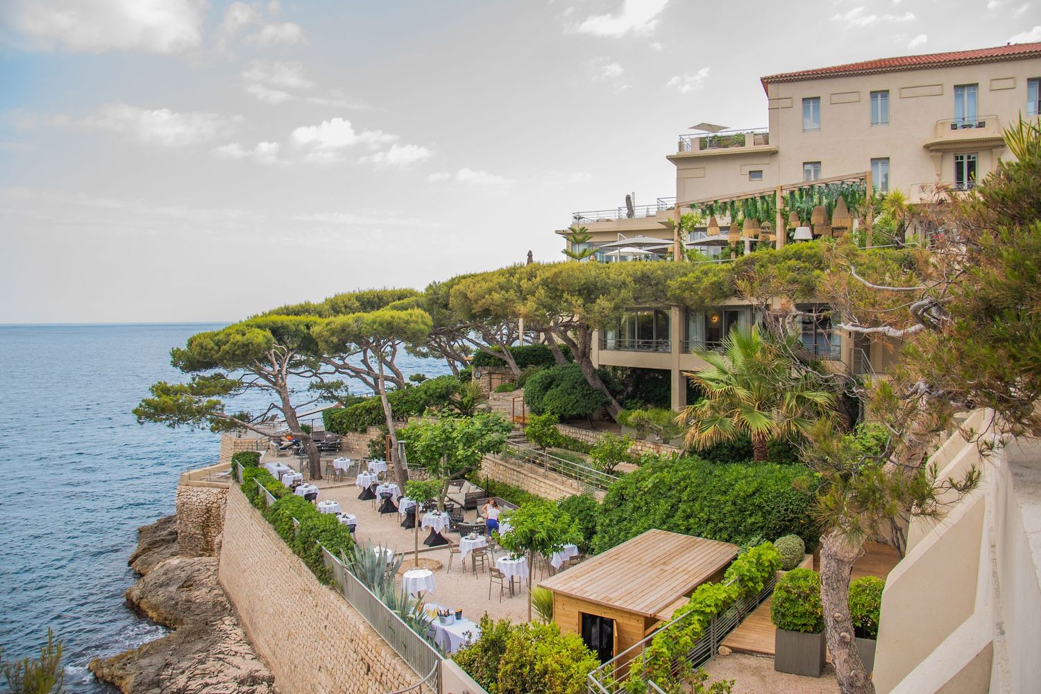 A scenic coastal town with Mediterranean-style buildings perched on cliffs overlooking the turquoise sea.
